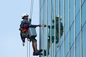 Man suspended on skyscraper cleaning windows